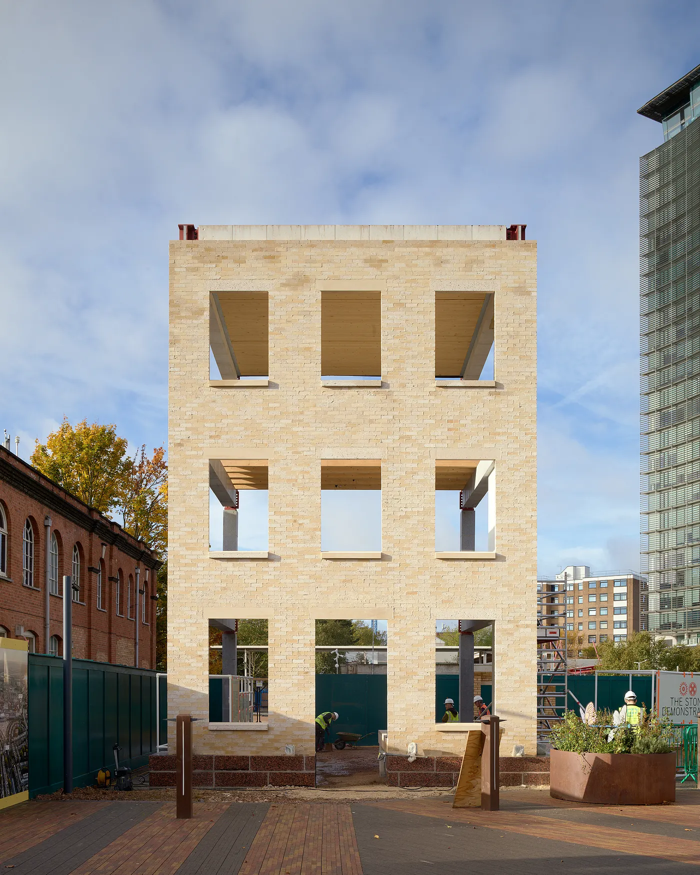 Stone Demonstrator under construction showing stone brick structure and workers on site