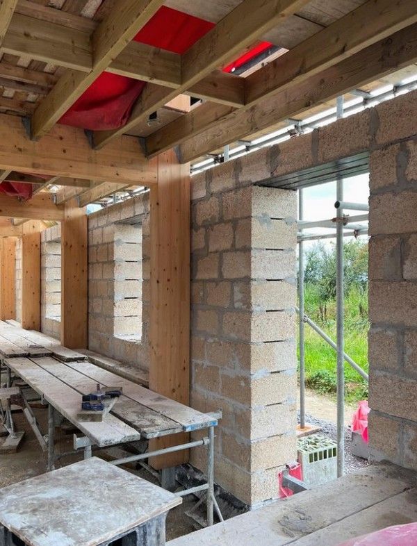 Hempcrete blocks being laid inside a timber frame on the Bude project